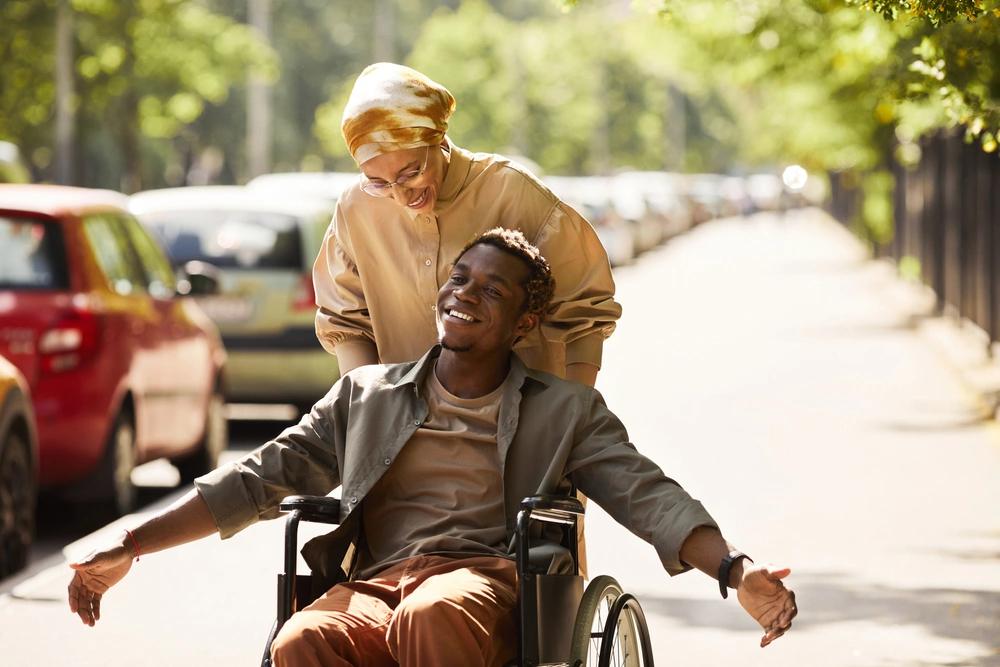 women with a disabled man on wheelchair walking on sidewalk