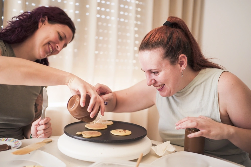 carer making pancakes with disabled women