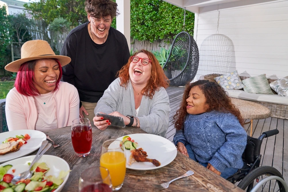 Group of friends with different disabilities watching something funny phone